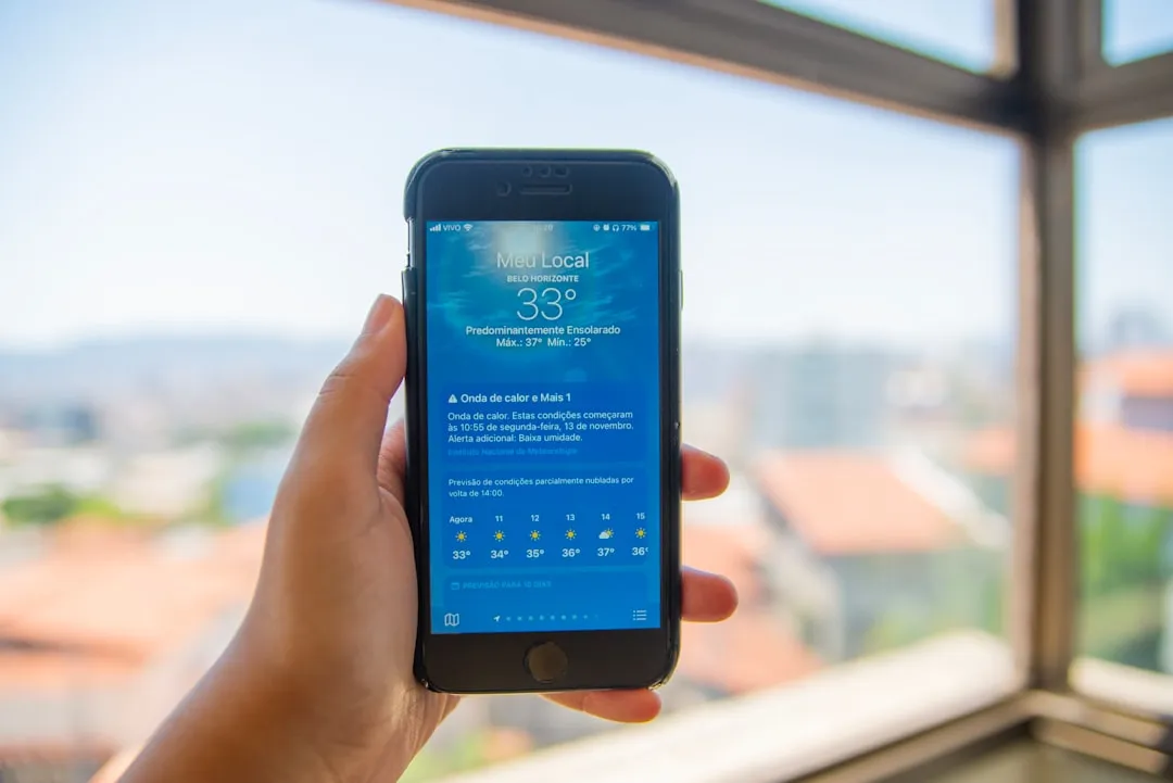 Uma pessoa segurando um telefone celular na frente de uma janela