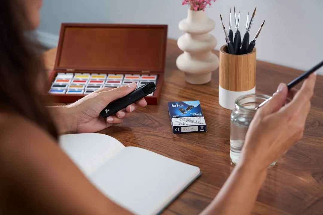 Uma mulher sentada à mesa com uma caneta e um caderno