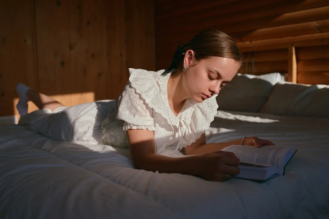 Uma mulher deitada na cama lendo um livro